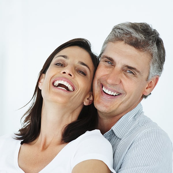A couple smiling after their dental veneers treatment